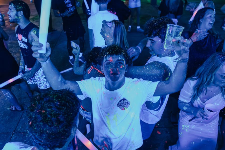 Friends in glow gear lit blue at a PCB Club Card party