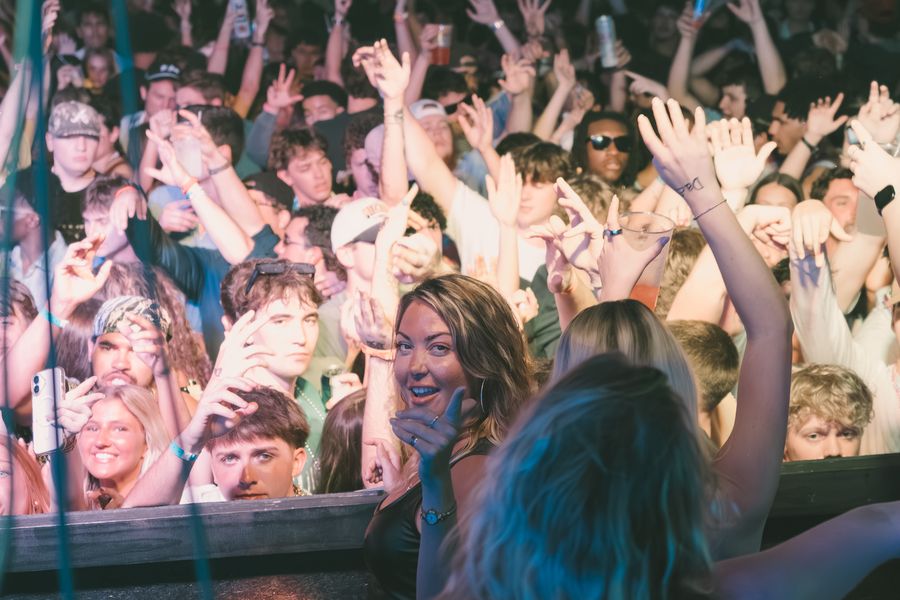 Packed crowd with hands in the air at a PCB Club Card party