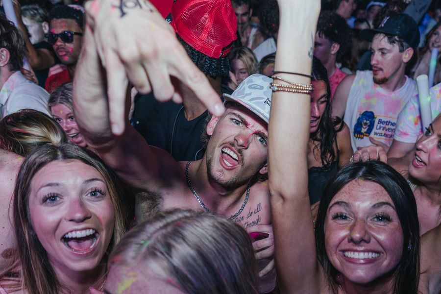 Crowd screaming with hands up at a PCB Club Card party