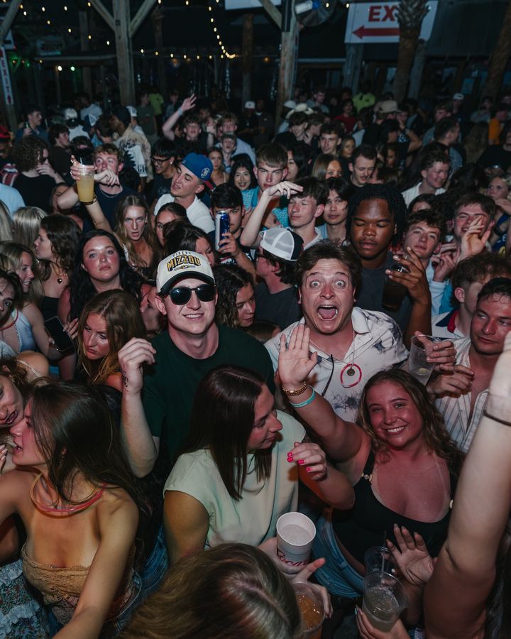 Crowd smiling at the camera at a Spring Break party