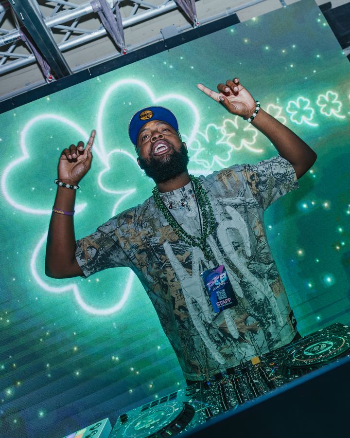 DJ in front of a shamrock screen